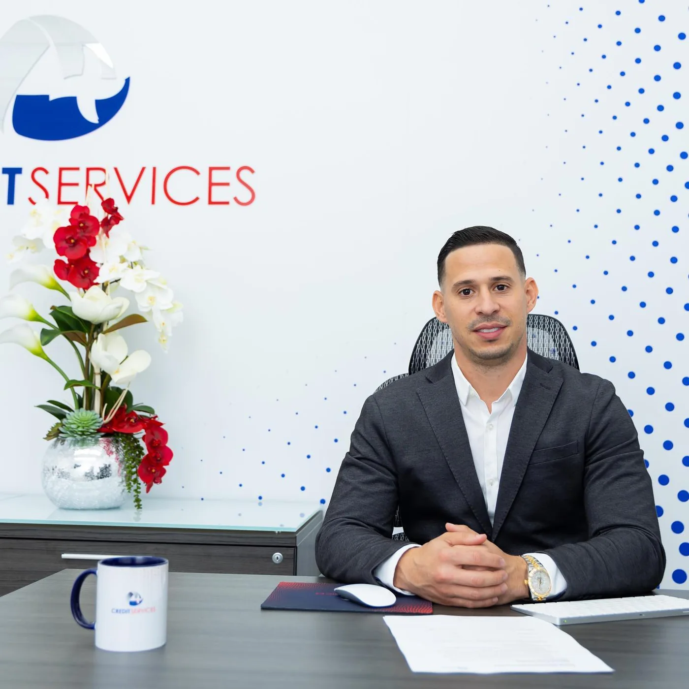 Adony Pérez at his desk in the A Plus Credit Services office